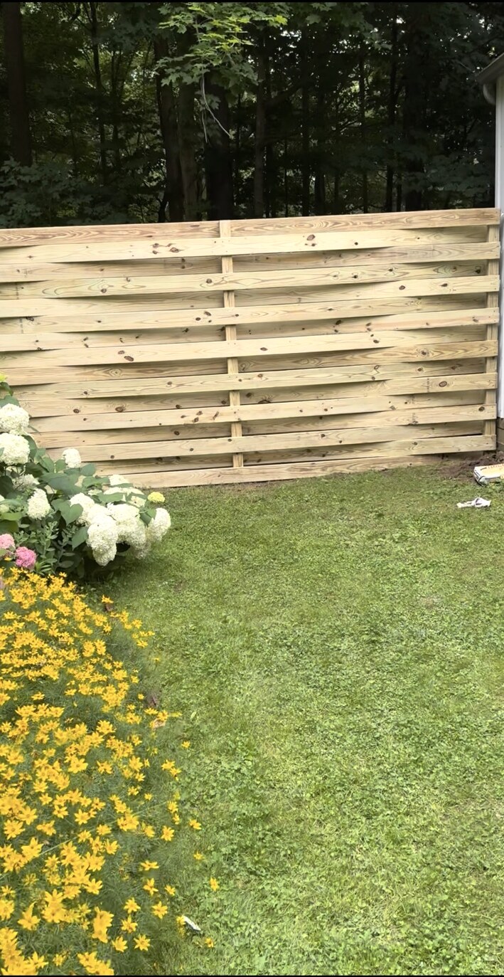 Custom horizontal wood privacy fence beside a landscaped yard